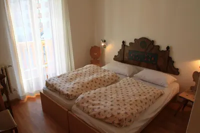 two twin beds in a room with a window at Casa Elisa in Pozza di Fassa