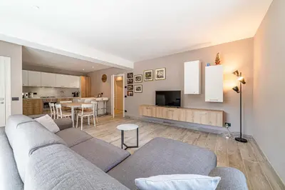 a living room with a couch and a kitchen at Blizzard apartments in Arabba