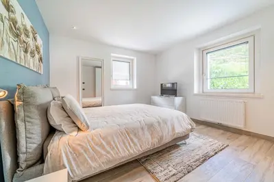 a bedroom with a bed and a couch and a window at Blizzard apartments in Arabba