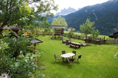 a garden with a table and chairs and a playground at Gasleidhof in Funes