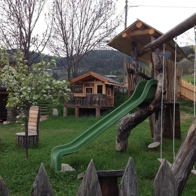 a playground with a green slide in a yard at Gasleidhof in Funes