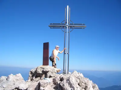 a man standing on top of a cross on a mountain at Gasleidhof in Funes