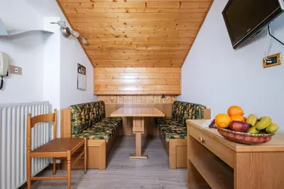 a hotel room with two beds and a balcony at Appartamenti Bel Sit in Canazei