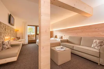a living room with a couch and a bed at Berggasthof Häusler in San Lorenzo di Sebato