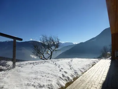 a snow covered hill with a view of mountains at Berggasthof Häusler in San Lorenzo di Sebato