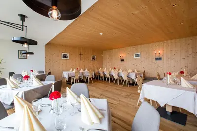 a banquet hall with white tables and chairs at Berggasthof Häusler in San Lorenzo di Sebato