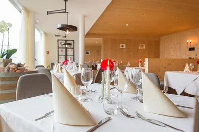 a table in a restaurant with white table cloths at Berggasthof Häusler in San Lorenzo di Sebato