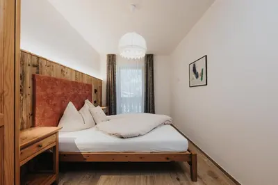 a kitchen with wooden cabinets and a lamp on a counter at Residence Obermoarhof - Family Apartments with Pool & Playground in Vandoies