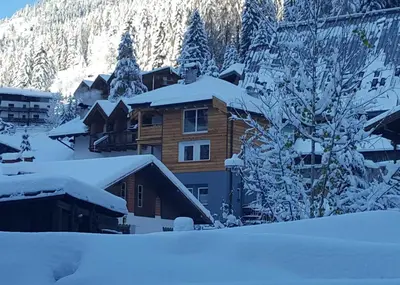 a dining room with a wooden table and chairs at La Tana dell'Orso in Campitello di Fassa
