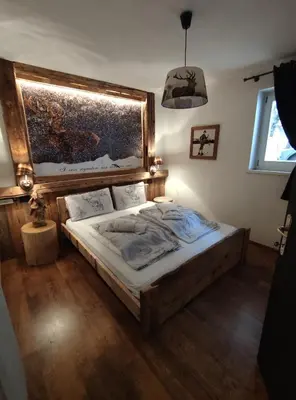 a bedroom with a bed and a painting on the wall at La Tana dell'Orso in Campitello di Fassa