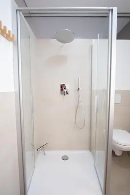 a glass shower in a bathroom with a toilet at Apartment Hanna in Merano