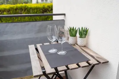 two wine glasses sitting on a table on a balcony at Apartment Hanna in Merano