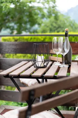a picnic table with two wine glasses and a bottle at Apartment Hanna in Merano