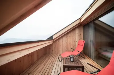 a red chair sitting on the balcony of a house at Kristplonerhof in Bolzano