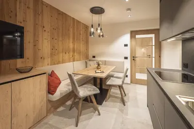 a kitchen with a table and chairs and a sink at App. Promberger in San Lorenzo di Sebato