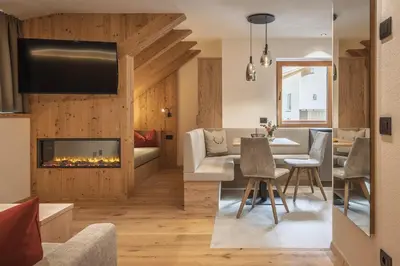 a living room and dining room with a fireplace at App. Promberger in San Lorenzo di Sebato
