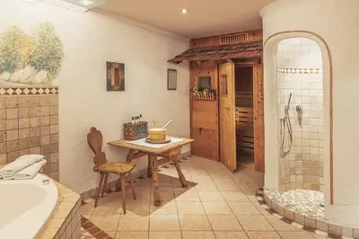 a bathroom with a table and a tub and a sink at App. Promberger in San Lorenzo di Sebato