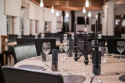 a table with wine glasses and candles on it at Hotel Hurtmuehle Kronblick in San Lorenzo di Sebato