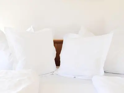 two white pillows sitting on top of a bed at Hotel Hurtmuehle Kronblick in San Lorenzo di Sebato