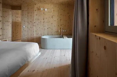 a bedroom with a bed and a bath tub at Odles Lodge in Bressanone