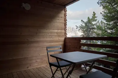 a table and chairs on the porch of a cabin at Odles Lodge in Bressanone