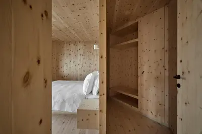 a bedroom with a bed in a wooden room at Odles Lodge in Bressanone