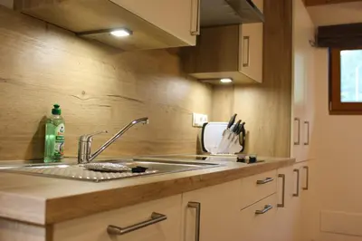 a kitchen with a stainless steel sink and wooden cabinets at Appartements Pixner in Saltusio