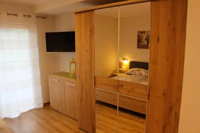 a bedroom with a large wooden cabinet with a bed at Appartements Pixner in Saltusio