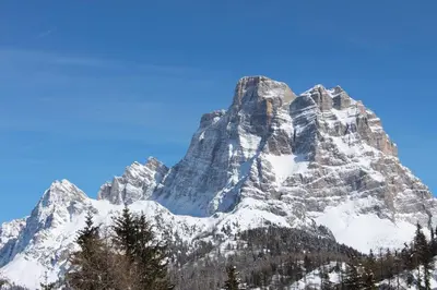 a mountain covered in snow with a blue sky at Cesa DOLOMITI in Rocca Pietore
