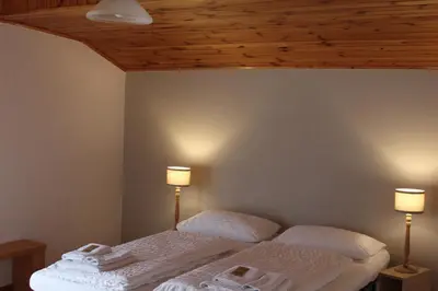 a bedroom with a bed with two lamps on it at Cesa DOLOMITI in Rocca Pietore