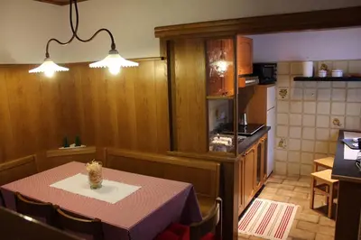 a dining room with a table and a kitchen at Cesa DOLOMITI in Rocca Pietore