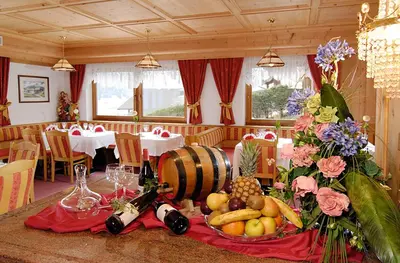 a table with a plate of fruit and wine bottles at Hotel Talblick in Ortisei