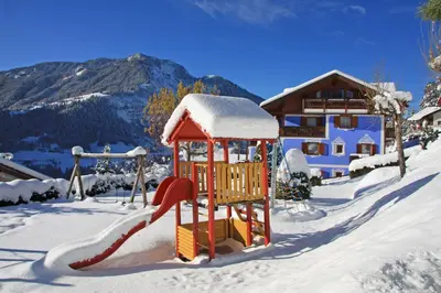 a playground in the snow with a slide at Hotel Talblick in Ortisei