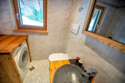 a bathroom with a sink and a washing machine at Chalet Aghel in Santa Cristina in Val Gardena