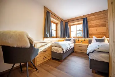 a bedroom with two beds and a desk and a chair at Chalet Aghel in Santa Cristina in Val Gardena