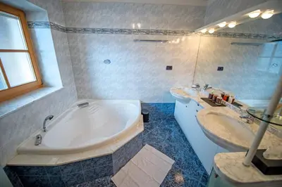 a bathroom with a large tub and two sinks at Chalet Aghel in Santa Cristina in Val Gardena