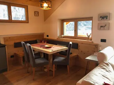 a dining room with a wooden table and chairs at Cèsa Prinoth in Campitello di Fassa