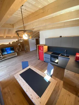 a kitchen with a table and chairs in a room at Cèsa Prinoth in Campitello di Fassa