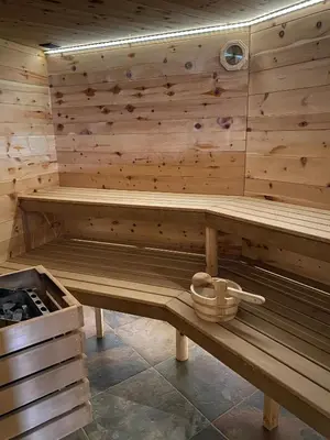a wooden sauna with a bench in a room at Cèsa Prinoth in Campitello di Fassa
