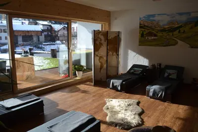 a living room with a table and a large window at Cèsa Prinoth in Campitello di Fassa