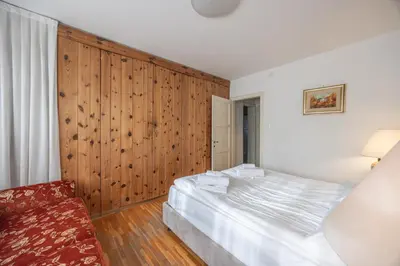 a bedroom with a large bed and a wooden wall at Casa Faloria in Cortina dʼAmpezzo