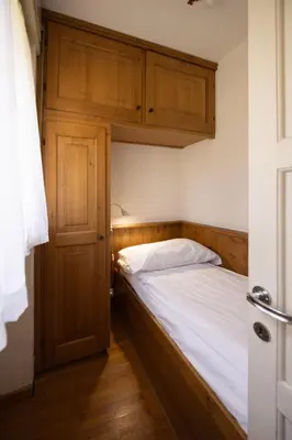 a bedroom with a bed with a wooden headboard at Casa Faloria in Cortina dʼAmpezzo