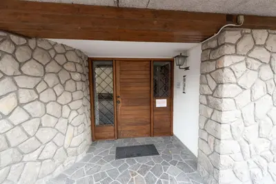a front door of a house with a stone wall at Casa Faloria in Cortina dʼAmpezzo