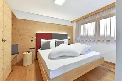 a bedroom with a large bed with white pillows at Forchnerhof Panorama - Dolomitenblick in Rodengo