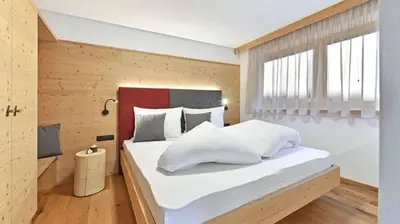 a bedroom with a large bed with white pillows at Forchnerhof Panorama - Dolomitenblick in Rodengo