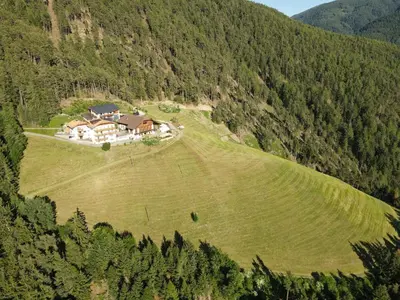an aerial view of a house on a green field at Forchnerhof Panorama - Dolomitenblick in Rodengo