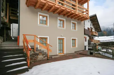 a house with a staircase in front of it at Casa Piccolin in Falcade