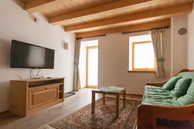 a living room with a flat screen tv and a couch at Casa Piccolin in Falcade