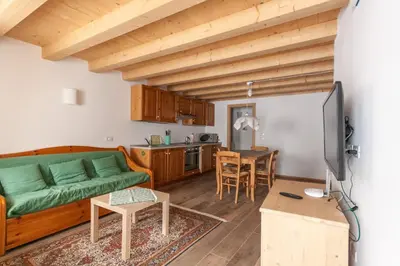 a living room with a green couch and a table at Casa Piccolin in Falcade
