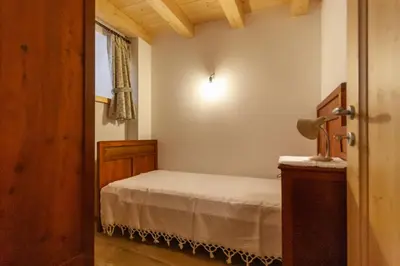 a small bedroom with a bed and a window at Casa Piccolin in Falcade